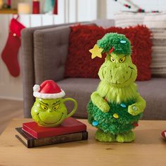 the grinch is sitting next to the coffee mug