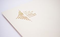 a white folder with gold foil on it