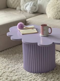 a purple coffee table with a book and cup on it