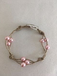 a bracelet with pink pearls on it