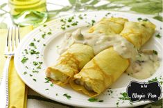 two crepes on a white plate with sauce and parsley