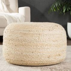 a large round jute ottoman sitting on top of a rug in a living room