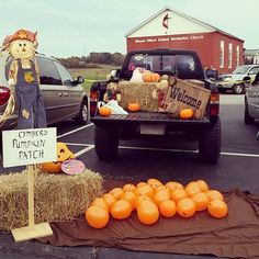 pumpkins and hay bales in the back of a truck with a scarecrow on it