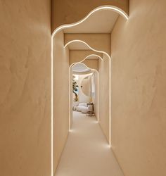 the hallway is lit up with white lights and an arch between two walls that lead to another room