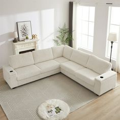 a living room with a sectional couch and rug on the floor in front of a fireplace