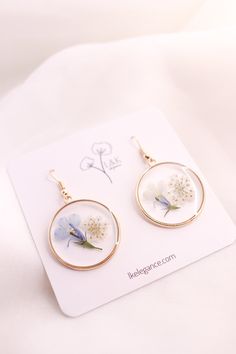 These lovely earrings are made from multiple layers of resin, Forget Me Not flowers, and Queen Ann's Lace flowers.Since real flowers are used for this piece, please note that there will be some variations in the flowers and branches. However, this is what makes each piece unique and one of a kind. Size: About 1.5" (2" with hooks) Cheap Pressed Flowers Earrings, Cheap Pressed Flower Earrings, Cherry Blossom Earrings Pressed Flower, Forget Me Not Resin Earrings, Pressed Flower Earrings, Forget Me Not Flowers, Lovely Earrings, Pressed Flower, Clear Resin