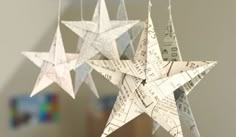 three white paper stars hanging from strings with numbers on them and music notes attached to them