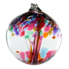 a colorful glass ornament with a tree on it