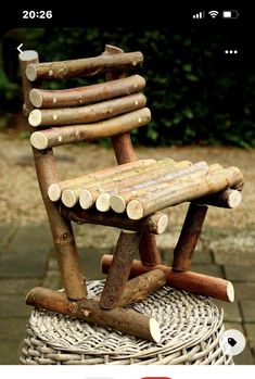 a chair made out of logs sitting on top of a wicker basket