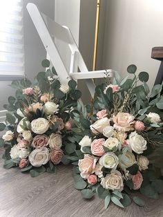 two bridal bouquets sitting on top of a wooden floor next to a chair