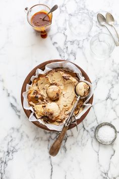 a bowl filled with ice cream sitting on top of a table next to spoons