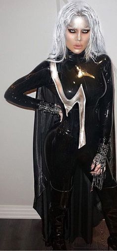 a woman dressed in black and silver posing for the camera