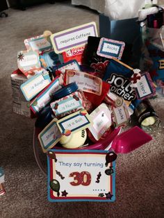 a basket filled with lots of different items on top of a carpeted floor next to a table