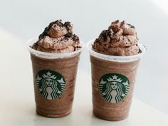 two cups filled with chocolate ice cream on top of a table