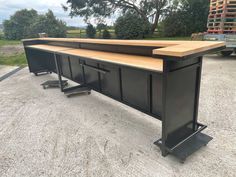 an outdoor table with two benches on it and some other tables in the back ground