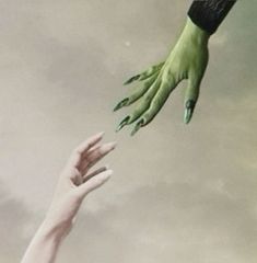 two hands reaching out towards each other in the sky with green painted nails on their fingers