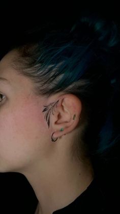 a woman with blue hair and piercings on her ear