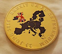 a gold coin with an image of the united kingdom in black and red on it