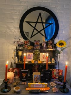 a table topped with candles and pictures next to a star shaped mirror on top of a wall