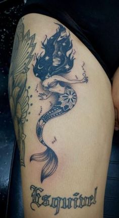 a woman's thigh with a mermaid tattoo on it