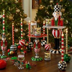 christmas decorations and candles on a table in front of a christmas tree