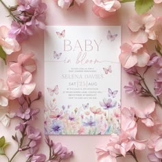 a baby is born card surrounded by pink and purple flowers on a light pink background