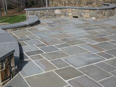 an outdoor patio with stone walls and benches