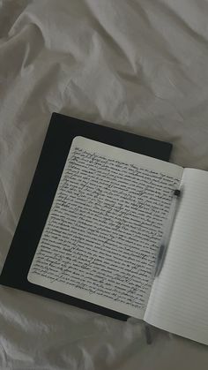 an open notebook and pen sitting on top of a sheet of paper with writing in it