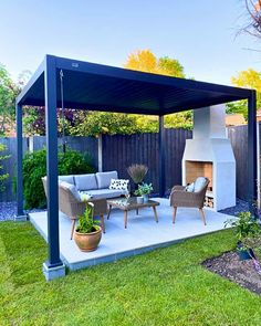 an outdoor living area with furniture and a fire place in the middle of the yard