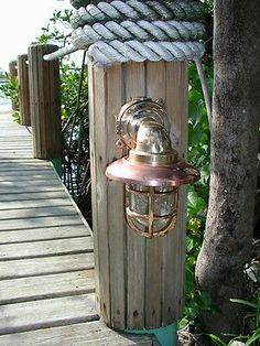 a lamp on the side of a wooden walkway