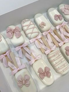 a box filled with lots of white and pink decorated cookies