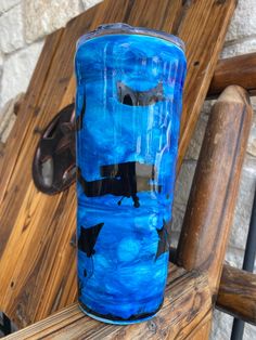 a blue glass sitting on top of a wooden chair