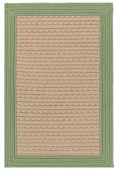 a green and beige area rug with braiding on the bottom, in front of a white