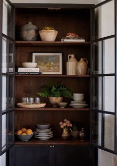 an open bookcase filled with plates and bowls