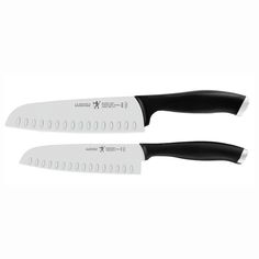 two large knives with black handles on each side and white blades at the end,