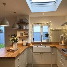 a kitchen filled with lots of counter top space next to a sink and oven under a skylight