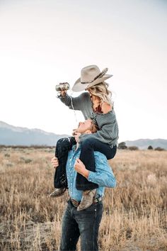 a woman holding a child in the middle of a field