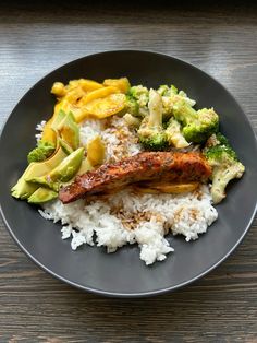 a plate with rice, broccoli, and meat on it sitting on a table