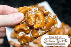 a hand holding up a piece of caramel brittle