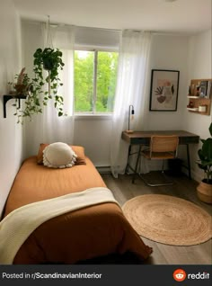 a bed sitting in a bedroom under a window next to a desk with a computer on top of it