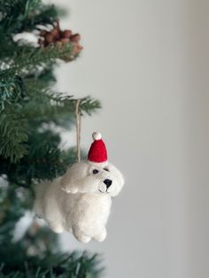 a white dog ornament hanging from a christmas tree