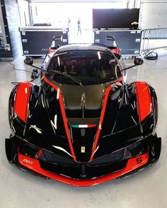 a black and red sports car parked in a garage