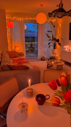 a living room filled with furniture and a white table topped with a vase full of flowers