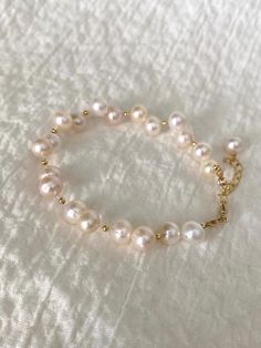 ✨ Welcome to The Pearly Loft ✨ Introducing 💖 Ariel 💖 - our stunning Freshwater Pearl Bracelet featuring an elegant Irregular Pearl design with 14K Gold Filled components. This Baroque Pearl Bracelet is perfect as a Bride Bracelet or a beautiful addition to your Minimalistic Jewelry collection. The Delicate Bracelet design is ideal for those who appreciate understated elegance and Boho Wrislet style. Handcrafted with care, Ariel showcases the natural beauty of Real Pearl Bracelet with its unique irregular pearls. The 14K Gold Filled accents add a touch of luxury, making this Elegant Bracelet a standout piece for any occasion. Whether you're looking for a versatile Everyday Bracelet or a Cute Wristlet to complement your outfit, Ariel is designed to impress. ✨ Details: - 6" inches + 2" inch Handmade Cute Pearl Bracelet, Hand-strung Pearl Bracelet, Gold Bracelets With Round Beads And Oyster Bracelet, Elegant Hand-strung Charm Bracelet, Hand-strung Wedding Bracelets, Handmade Yellow Gold Pearl Bracelet For Wedding, Yellow Gold Bracelets With Round Beads For Weddings, Single Strand Bracelet Jewelry Gift, Single Strand Bracelet As Gift