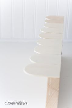 a stack of white plates sitting on top of a wooden table next to a wall