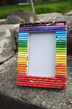 a multicolored photo frame sitting on top of a rock