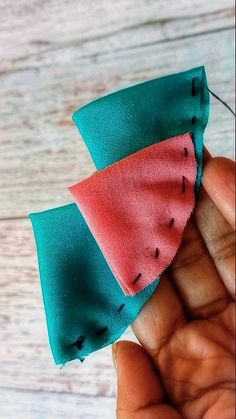 someone is stitching together two pieces of fabric to make an origami slice