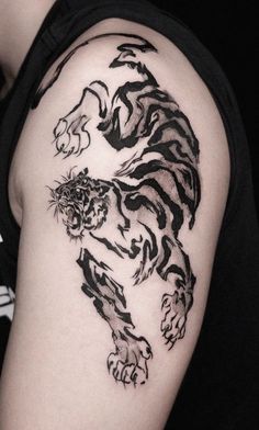 a black and white tiger tattoo on the arm