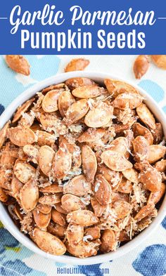 garlic parmesan pumpkin seeds in a white bowl on a blue and white towel