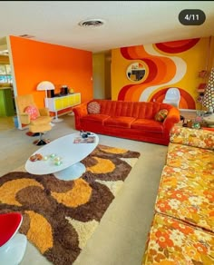 a living room filled with orange and yellow furniture on top of carpeted flooring